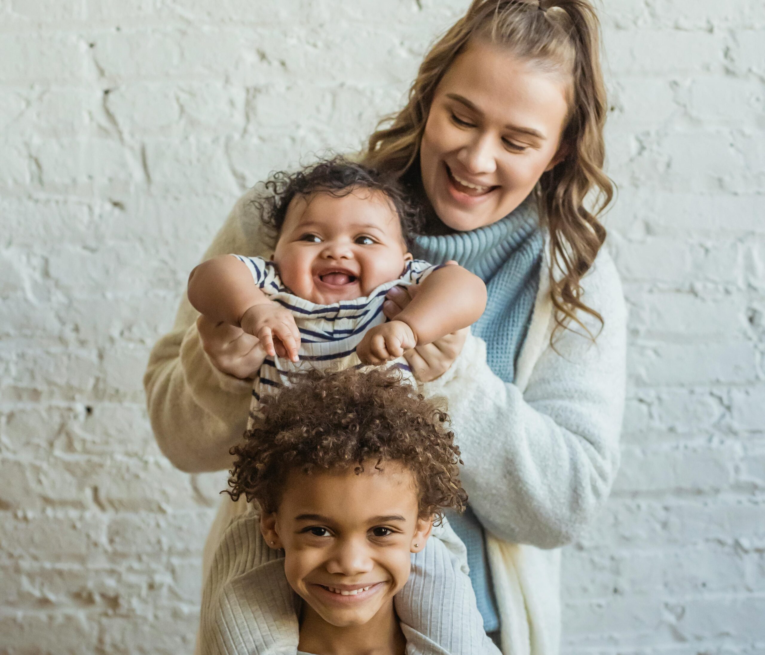 a smiling adult with 2 happy kids